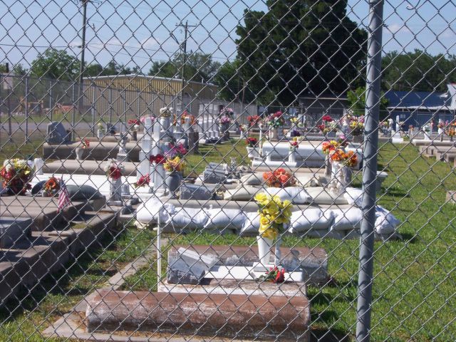 Grave surrounded by and topped with sand bags in a graveyard adjacent to Bayou Boeuf in Amelia.